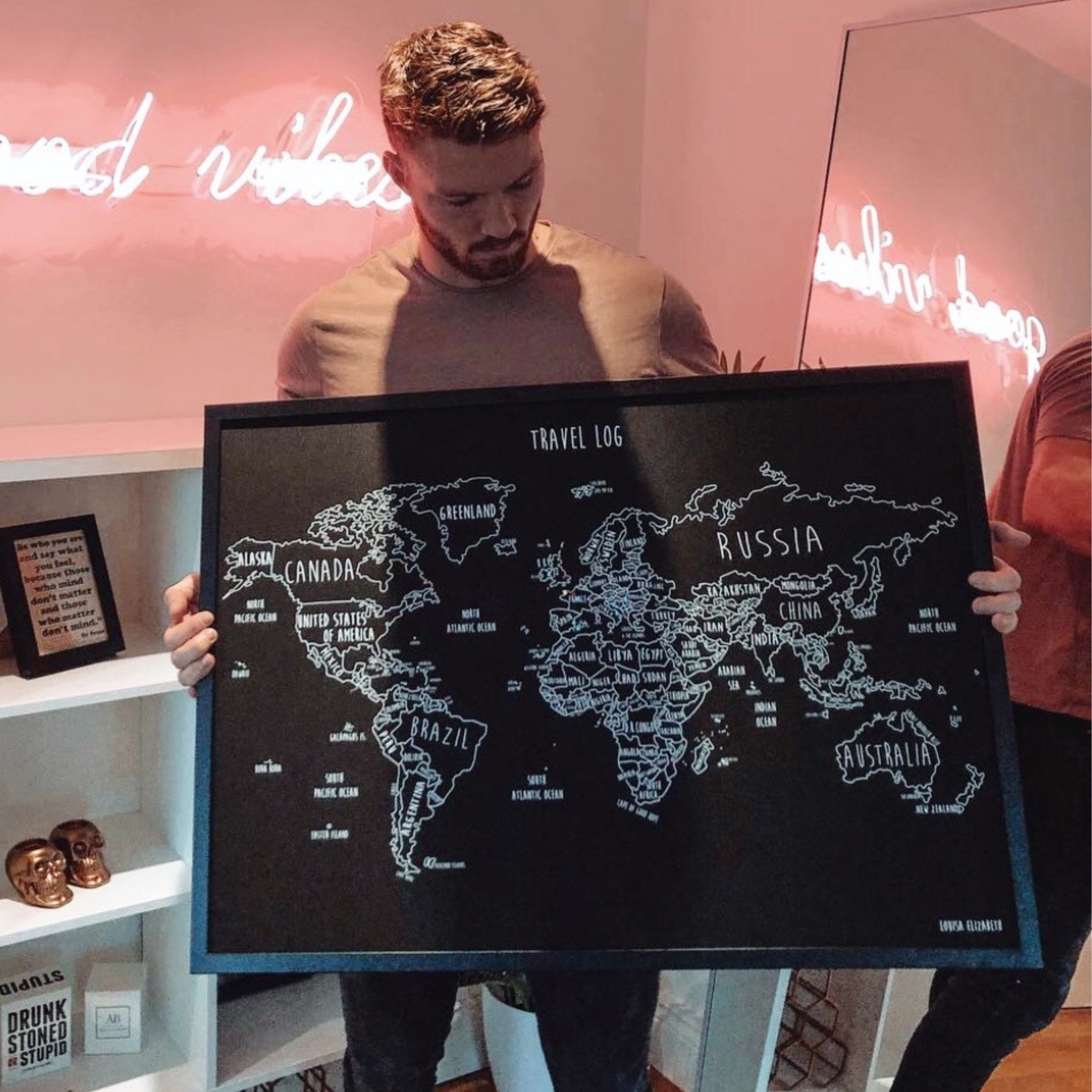 Customer holding a personalised black world pinboard map
