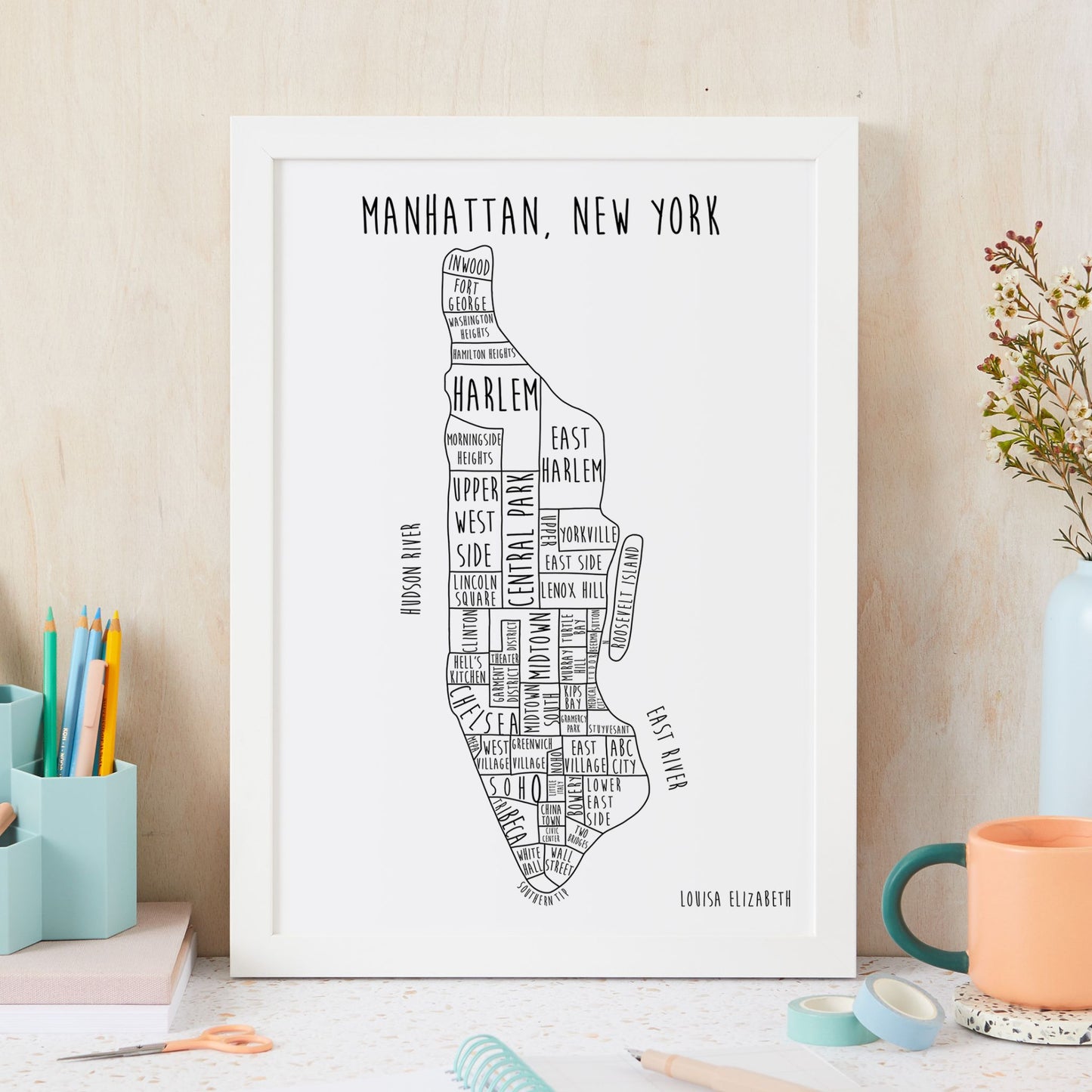 Framed map of Manhattan, New York with text on a desk.