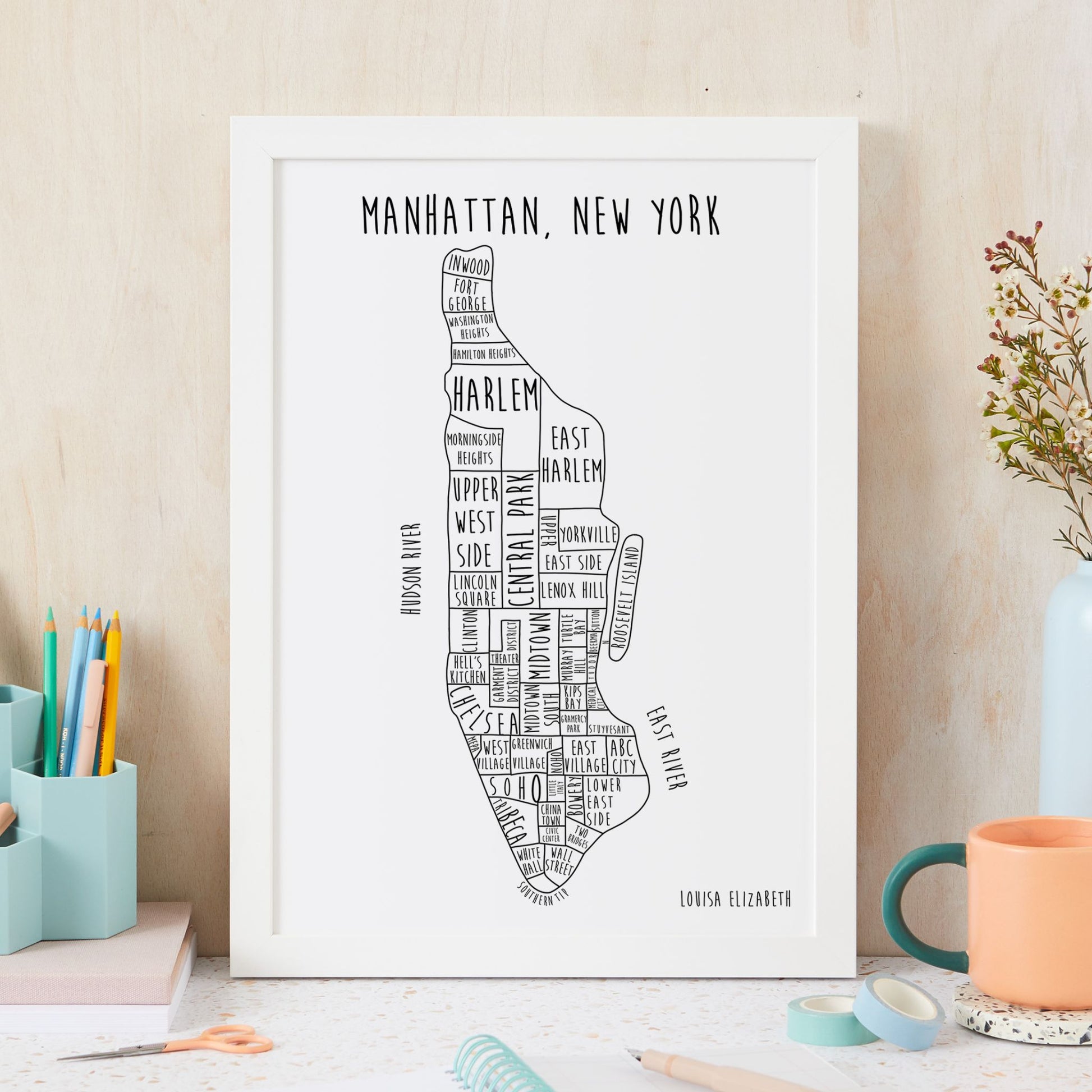 Framed map of Manhattan, New York with text on a desk.