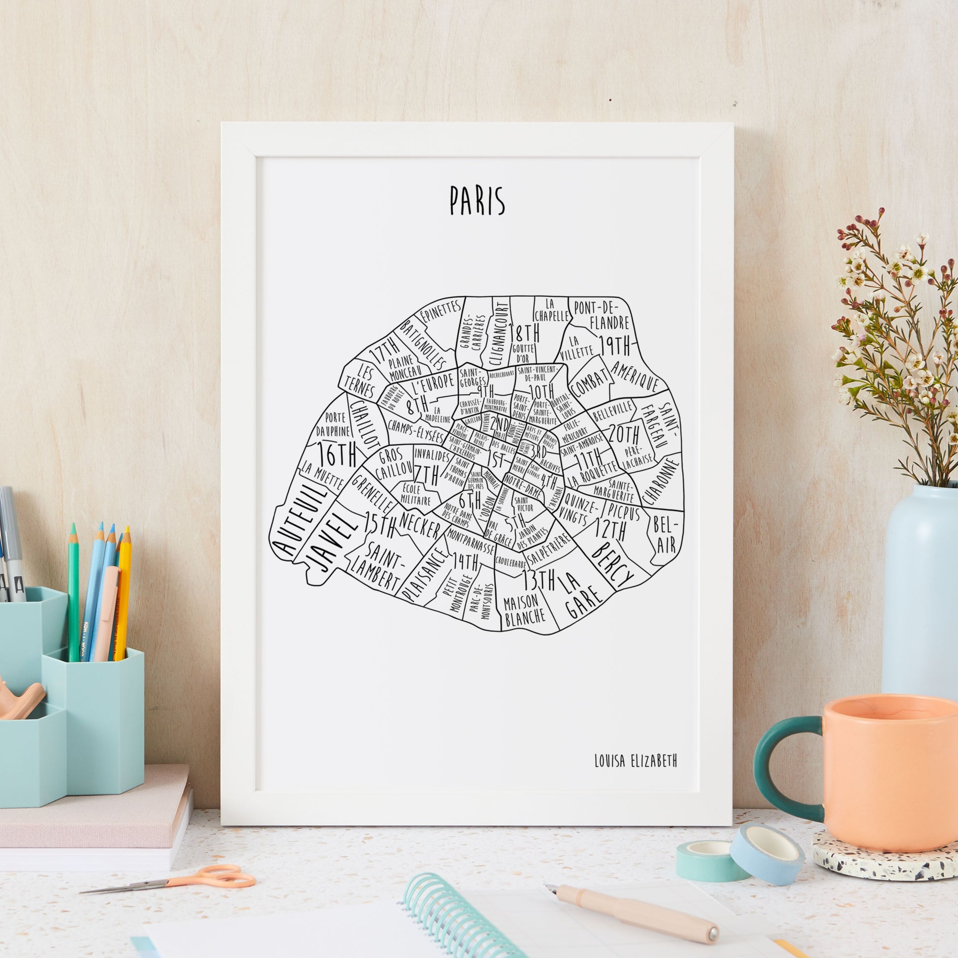 Framed map of Paris on a desk with stationery items