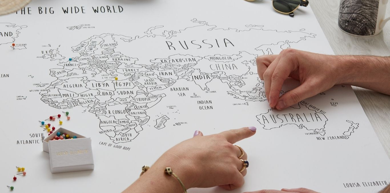 World map with pins on a table, indicating travel or exploration.